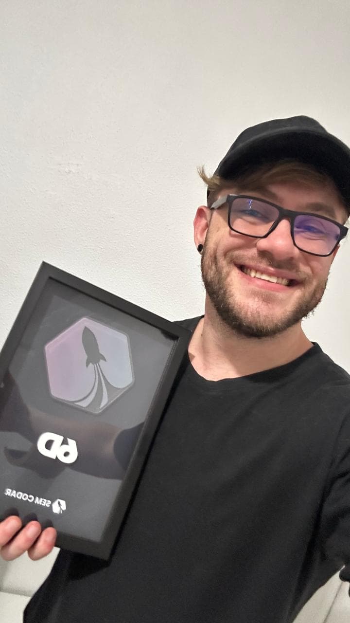 Alisson, criador do FlowUp, segurando uma placa de 6 dígitos